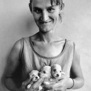 Wife of abattoir worker holding three puppies, Orange Free State, 1994